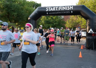 A group of runners and walkers crossing the finish line