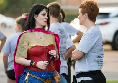 A short-haired woman talks to a woman dressed as Wonder Woman