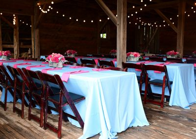 Banquet tables with white tablecloths and pink linen napkins