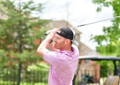 A red-headed man swinging a golf club