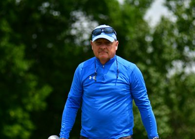 An older man wearing a blue pullover and light blue hat