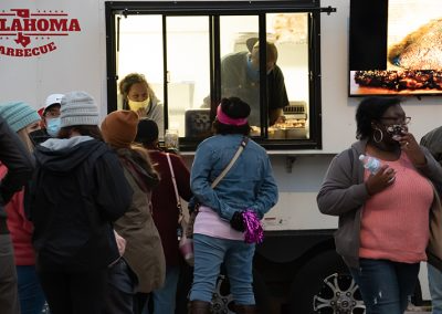 A line of people ordering food at a barbecue food truck