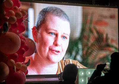 Video of breast cancer survivor talking on a big screen