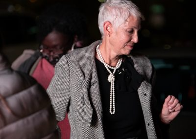 A older woman wearing a pearl necklace