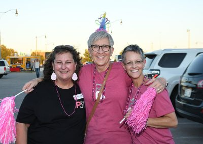 Three older women wearing pink