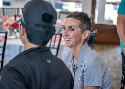 An woman with short hair laughs while talking with a young man