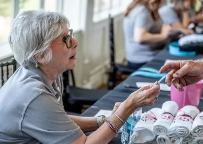 An older woman hands a raffle ticket to man