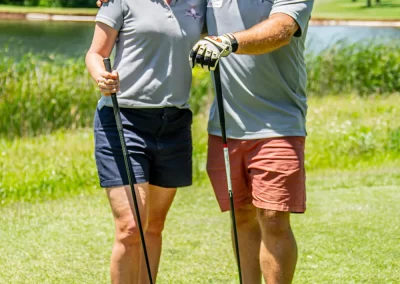 A middle-aged man and woman holding golf clubs on golf course