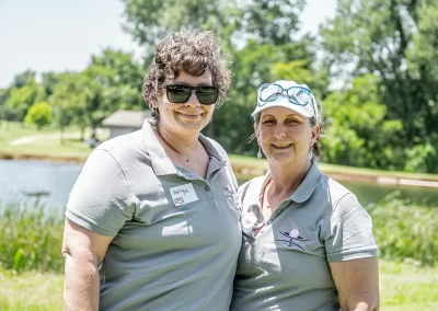 Two older women wearing grey P31 polos