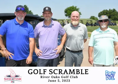 Four middle-aged men standing to the right of a golf cart wearing dark blue, purple, gray, and sea-foam green.