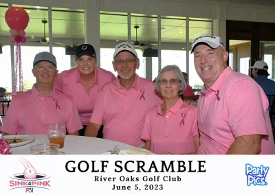 5 people, including Jerry and Brenda Murphy, wearing pink and gathered around a table at the club house.