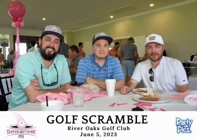 Three men, two wearing P31 caps and one in a white cap sitting at a table with a white table cloth