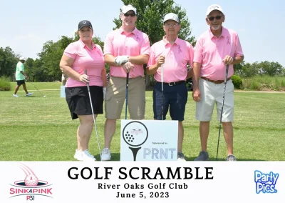 Two older men, one, younger man, and one woman outside with golf clubs. All are wearing pink.