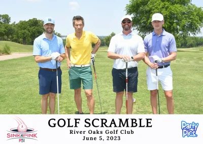 four men wearing colorful polos and holding golf clubs on golf course