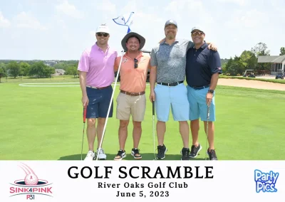 four men hugging and posing for photo on golf course