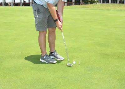 man putting with club in the background