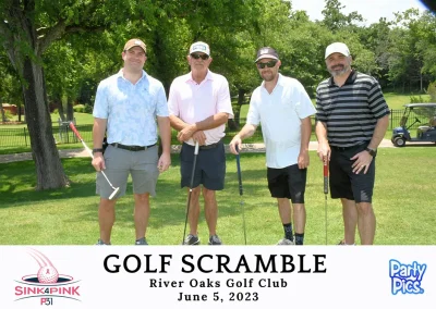 Four male golfers won the course posing in front of a path and golf cart