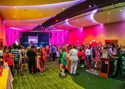 Event room full of people dressed in costumes mingling with one another and eating appetizers