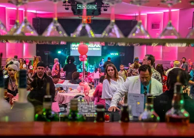 A crowd of adults in costumes wait in line at the bar