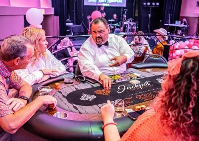 A blackjack dealer explains the game to a couple at a game table