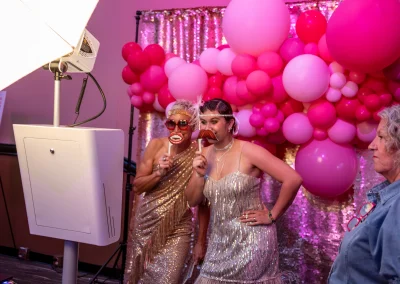 Women wearing flapper girl costumes posing for photo at a photobooth