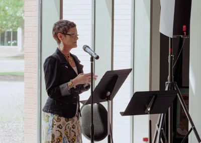 A breast cancer survivor speaks at a podium at the Survivor Luncheon in Tulsa.