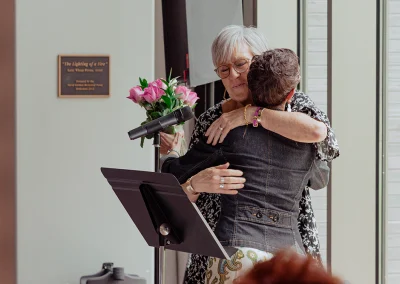 Two women hug at the podium at the Survivor Luncheon.