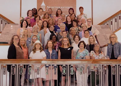 The group of attendees at the Survivor Luncheon take a group photo on the steps.