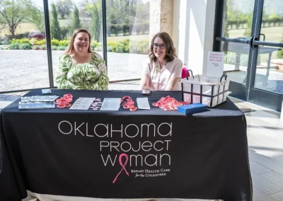 Two women sit behind their table representing Oklahoma Project Woman