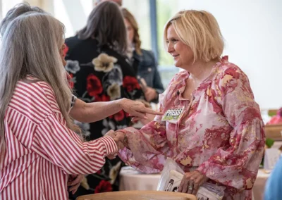 Two women shake hands and meet one another