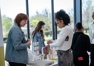 A woman tries on a Kendra Scott bracelet at the promotional table