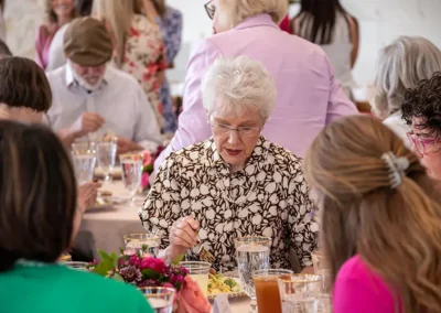 A woman looks down at her plate while eating her lunch