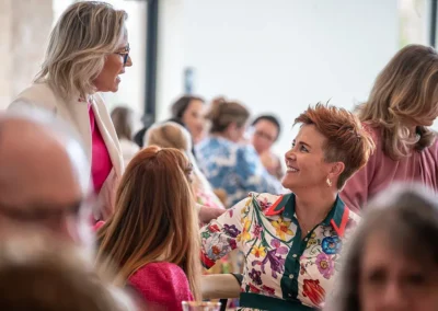 A woman stands while talking to another woman who is sitting down