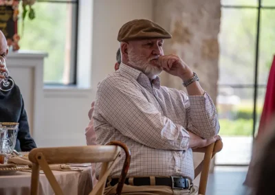 A woman holds his chin while listening to a speech