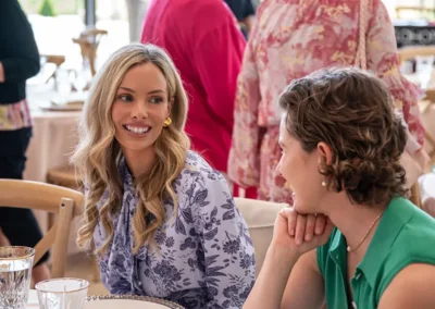 A woman smiles as she talks with the person sitting next to her.