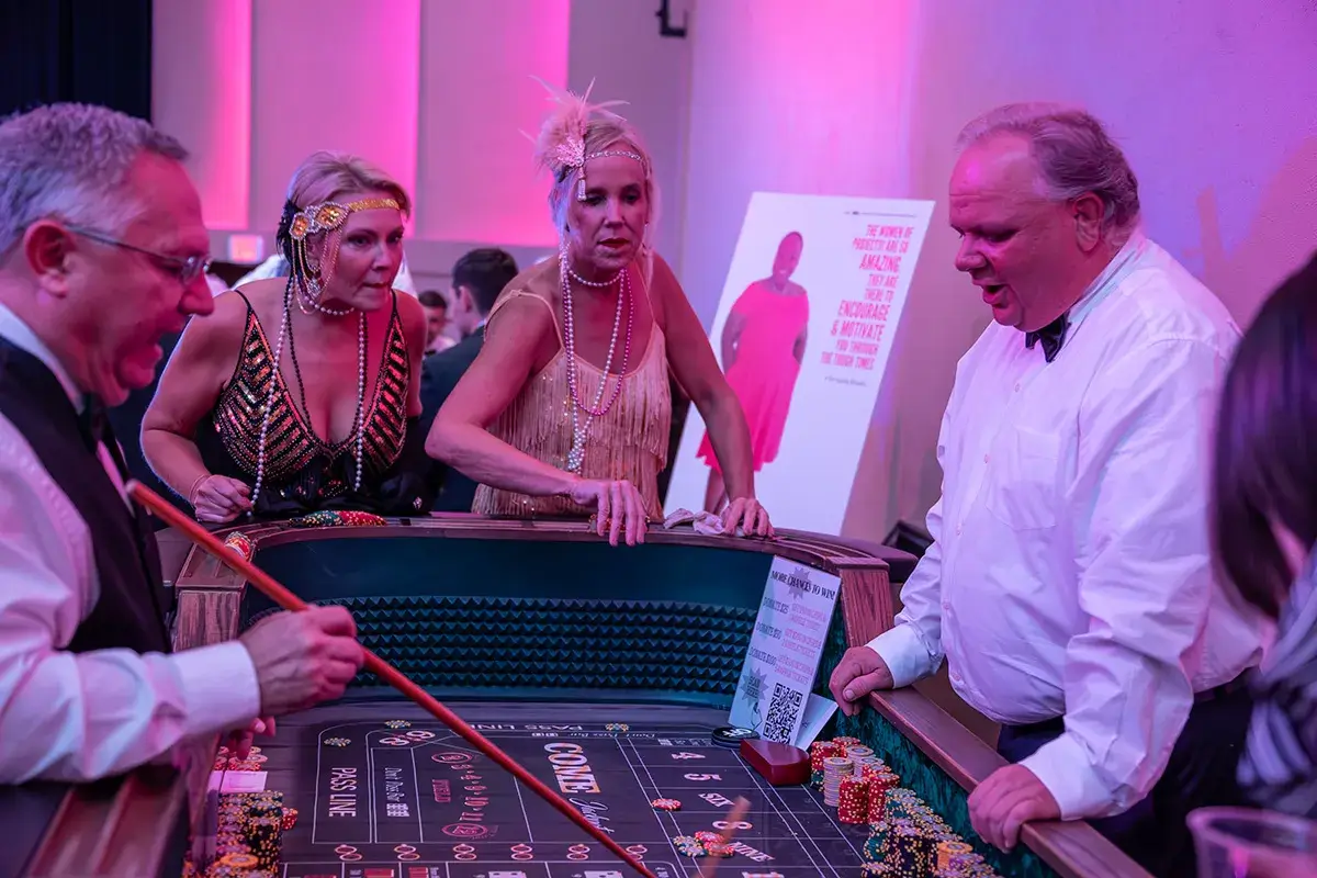 paint-the-town-pink-gala Two women play a casino game at a gala